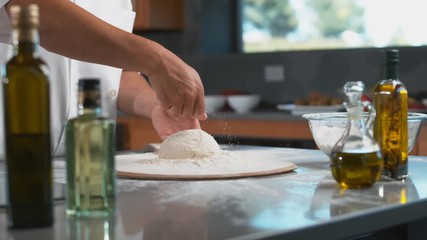 Chef sprinkles flour onto dough in super slow motion