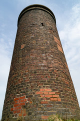 The old railway brick vent coming up through the English rural countryside.