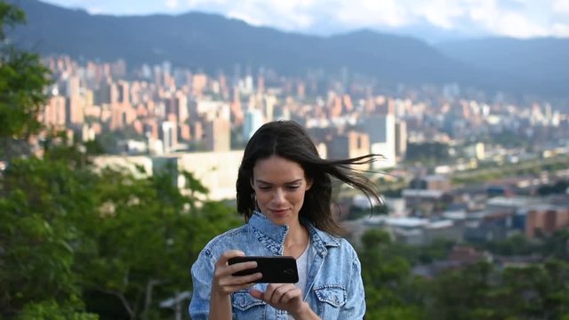 Happy tourist girl smiling and taking selfie with phone in city center, Cheerful young female posing and taking pics in landmark park