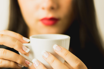 mujer joven tomando cafe  en una taza blanca