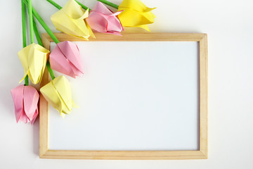 tulips of origami on a white background, a wooden frame