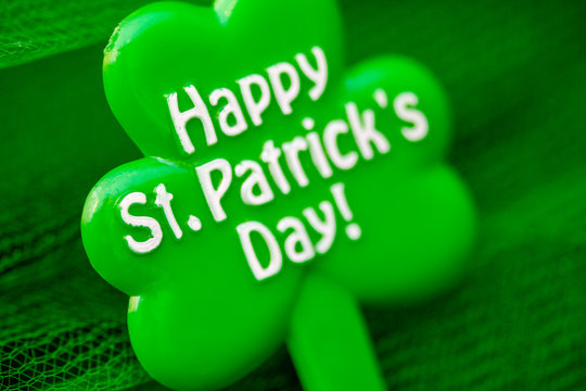 happy Patrick's day inscription on green maple leaf on green background