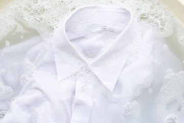 Fototapeta na wymiar Soak cloth before washing, white shirt