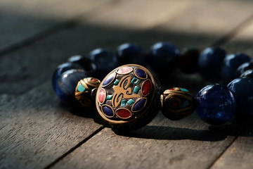 Kyanite bracelet in sunlight on wood vintage table and have space for write wording, popular unisex accessory with strong believe of healthy and lucky