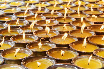 A lot of burning candles at a temple. Church interior