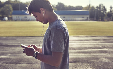 Sportive man at sunset listening music © shyshka