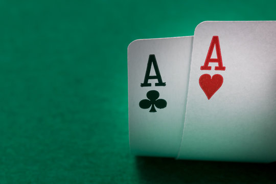 two aces poker cards close up on a green table