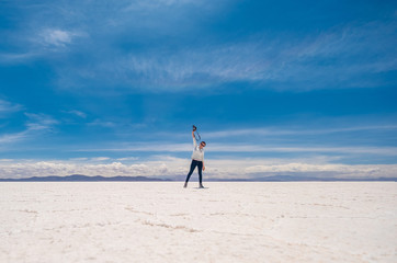 Girl in a jump in sunshine Salar de Uyuni