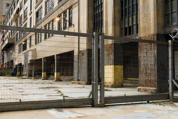 Industrial metal gate with abandoned building in background.  Chicago, Illinois, U.S.A.