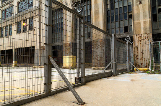 Industrial metal gate with abandoned building in background.  Chicago, Illinois, U.S.A.