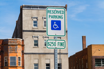 The "Reserved Parking for Disabled" sign with blue skies in the background.