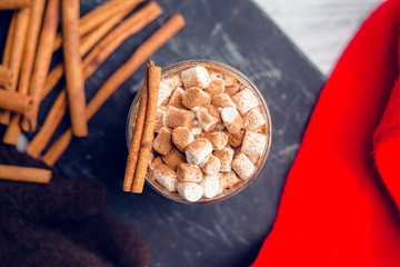 Hot Chocolate drink with marshmallow and cinnamon in old-fashioned glass. Selective focus.