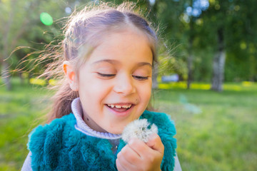 Little girl in green garden in sunny day