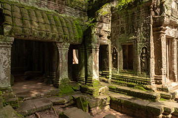 Fototapeta na wymiar Moss-covered columns and statues by temple doorway