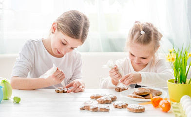 Obraz na płótnie Canvas Child girl decorating Easter cookies