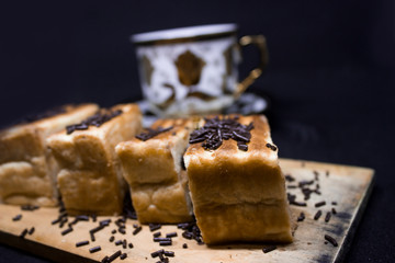 toast with chocolate sprinkles and tea to accompany relaxing time with a black background