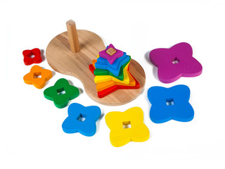 Photo of a wooden toys  children's sorter pyramid of colorful parts in the shape of flowerss on a white isolated background. The toy for the development of fine motor child