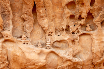 Cairns placed in a weathered wall of sandstone in Devils Garden Trail in Arches National Park, Utah