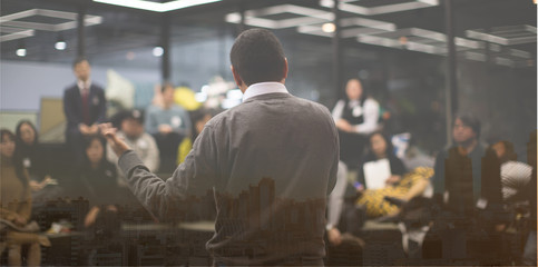 Speaker in Meeting at Business Conference Event. Seminar Audience Blurred in Training Room Watch Presentation. Presenter Giving Talk to People. City Landscape Exposure.