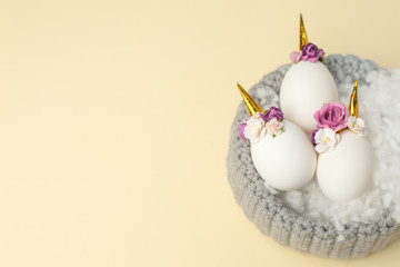 Easter holiday concept with cute handmade eggs, unicorn and flower decoration in bird nest