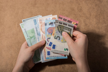 Hand holding American dollar  isolated on wooden background