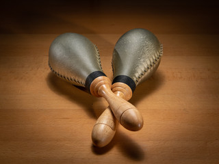 A pair of rawhide maracas lying on a wooden table