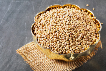 Dried lentils scattered on slate natural black background