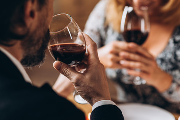 Man and woman drink red wine close up, focus on man