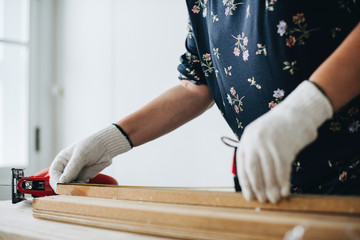 Woman measuring a wooden plank