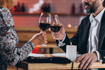 Middle aged couple in love.  dines in the restaurant, raises the glasses of wine close up