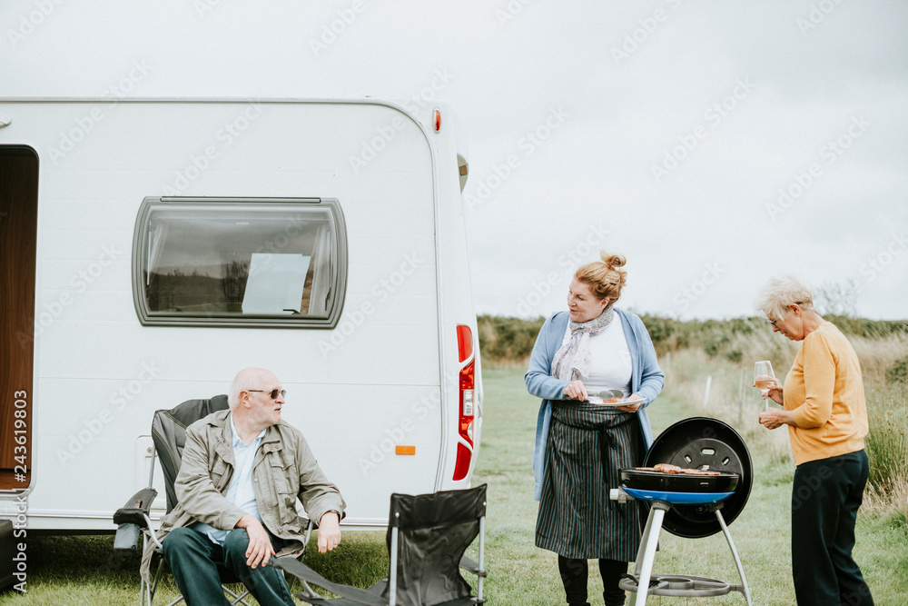 Wall mural elderly woman grilling delicious meat