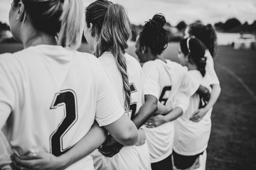 Female football players huddling together - Powered by Adobe
