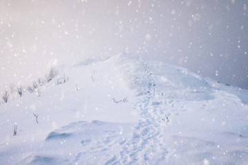 Fototapeta na wymiar Snowy mountain peak with footprints