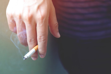 The man smoking a cigarette in hand. Cigarette smoke spread.	