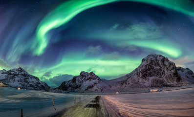 Northern lights explosion on snowy mountain range - obrazy, fototapety, plakaty