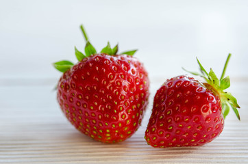 two strawberries on a wooden table