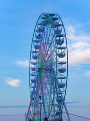 part of a big wheel in front of blue sky at evening time
