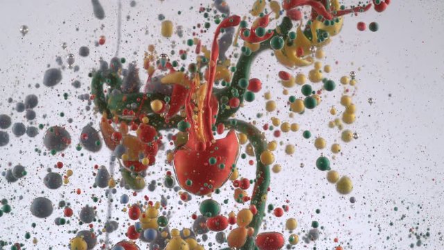 Slow motion shot of ink pouring into oil