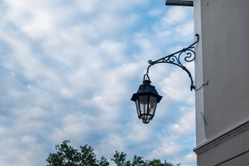 Old street lamp hanging from stone wall