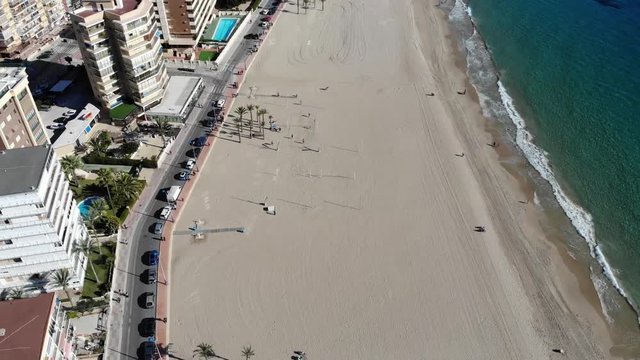 4k Aerial footage of the Beautiful Playa Levante beach in Benidorm a seaside resort in Spain Alicante, showing hotels, buildings, resturants and the coastline and sand.