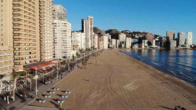 4k Aerial footage of the Beautiful Playa Levante beach in Benidorm a seaside resort in Spain Alicante, showing hotels, buildings, resturants and the coastline and sand.