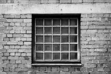 Urbane Backsteinwand mit Fenster aus Glasbausteinen in Schwarz-Weiss 