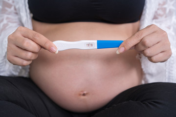 pregnant woman holding pregnancy test