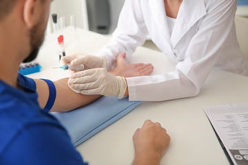 Female doctor preparing patient for blood draw in clinic