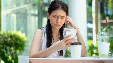 The young woman using smartphone with seriously