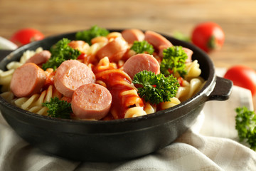 Delicious pasta with sausage and sauce on pan