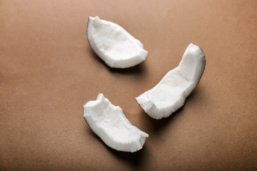 Pieces of coconut on color background