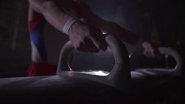 Sportsman chalking his hands before performance . Shot in slow motion.