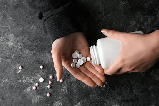 Woman going to take many pills, closeup. Suicide concept