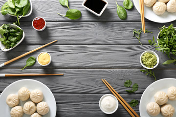 Fototapeta na wymiar Composition with tasty Chinese dumplings on wooden table